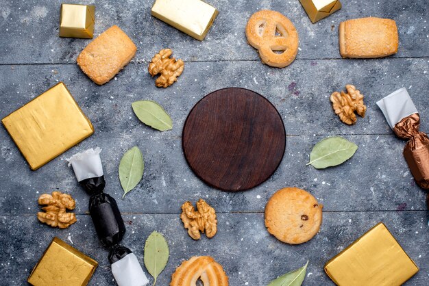 Top view of cookie and walnuts along with chocolate cake on grey, cookie biscuit chocolate