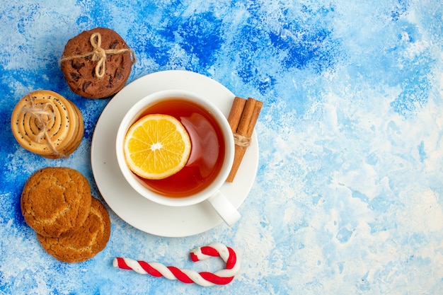 Top view cookies tied up with rope cup of tea xmas candy on blue table