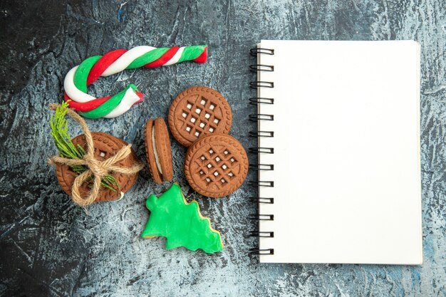 Free Photo top view cookies tied with ropes cookies xmas candies notepad on grey surface