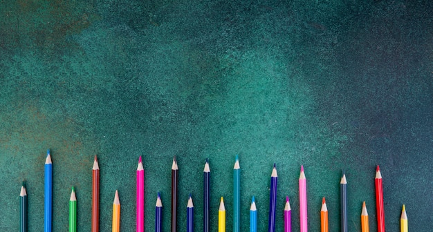 Free photo top view copy space colorful pencils on a green background