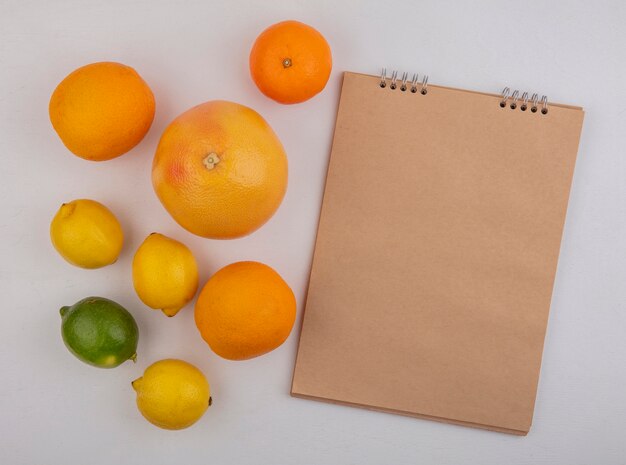 Top view  copy space grapefruit with oranges and lemons with notepad on white background