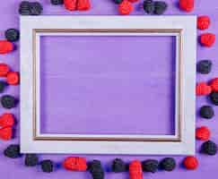 Free photo top view copy space gray frame with marmalades in the form of raspberries and blackberries on a purple background