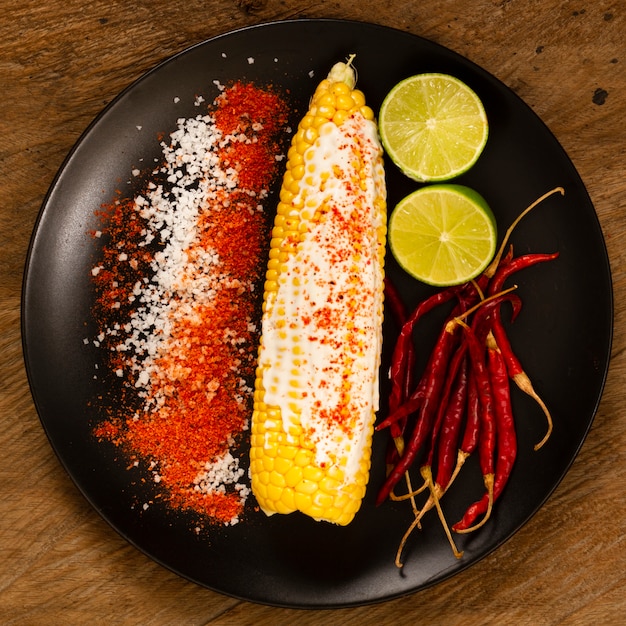 Free photo top view of corn on plate with limes