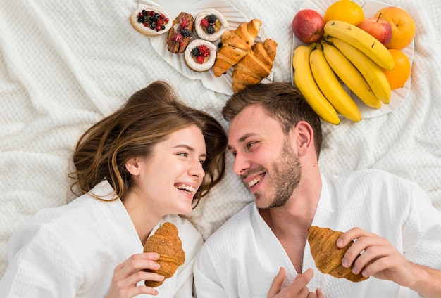 Free photo top view of coupe in bed with fruits and croissants