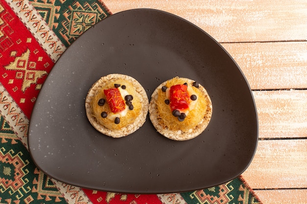 Free Photo top view of crackers and cakes inside brown plate