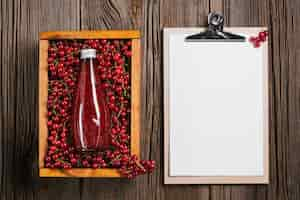 Free photo top view cranberries juice with clipboard