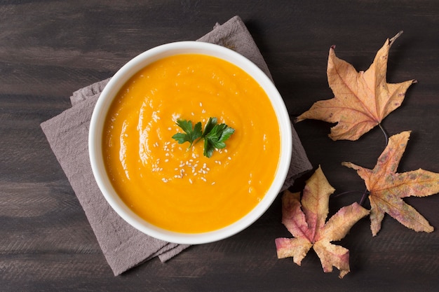 Top view cream soup and autumn leaves