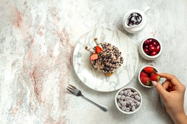 Free Photo top view creamy delicious cake with strawberries and candies on white surface birthday cream tea cake biscuit sweet cookie