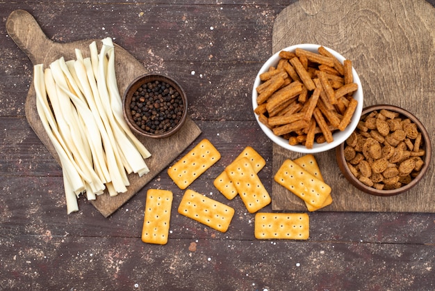 Free photo top view crisps and crackers with cheese on the brown wooden desk snack photo crisp cracker