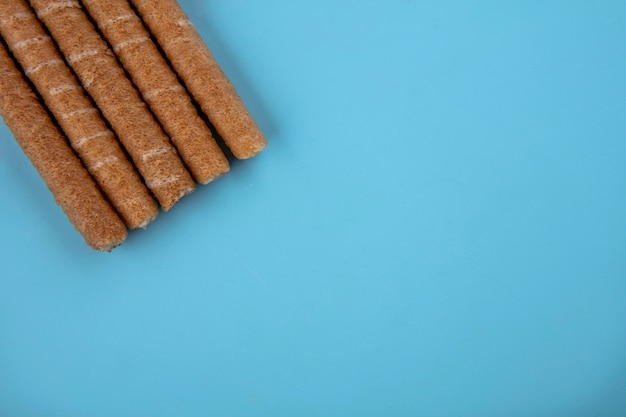 Top view of crispy sticks on blue background with copy space