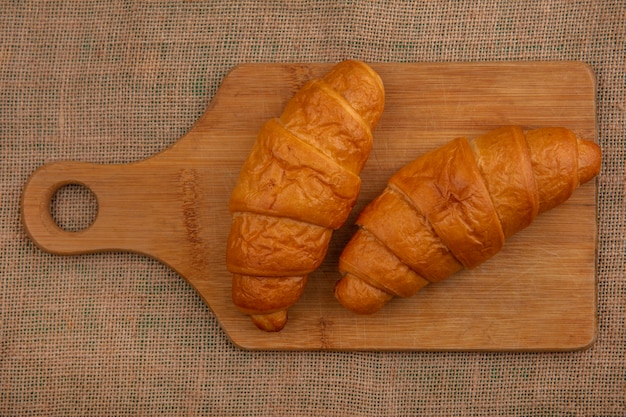 Free photo top view of croissants on cutting board on sackcloth background