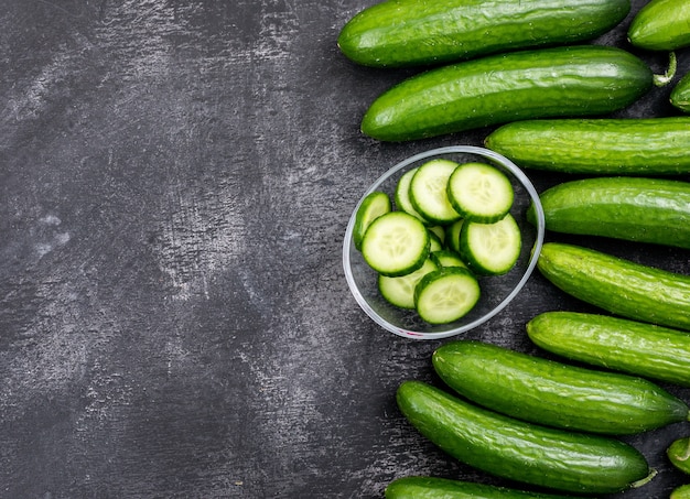 Top view cucumber sliced in glass bowl with copy space on black stone  horizontal