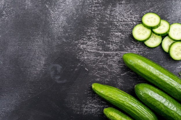 Free photo top view cucumber sliced with copy space on black stone  horizontal 1