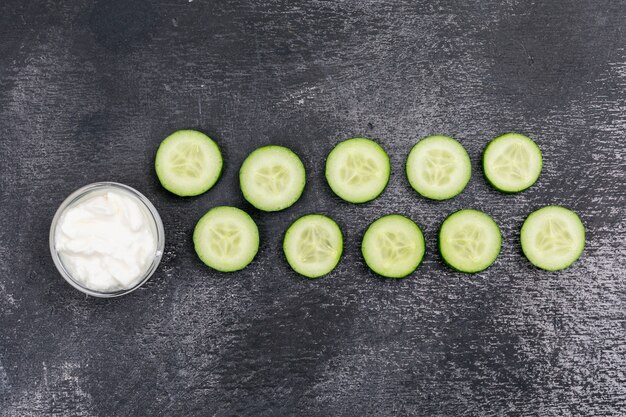 Top view cucumber sliced with white yogurt on black stone  horizontal