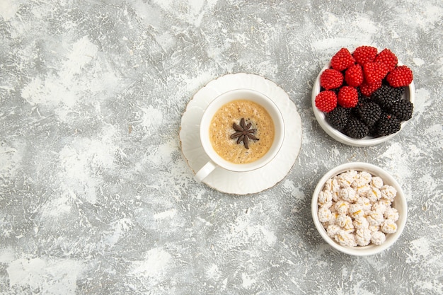 Top view cup of coffee delicious cappuccino with berries on the white surface