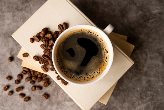 Free photo top view cup of coffee with books