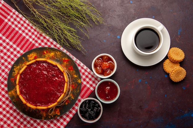 Top view cup of coffee with delicious dessert cake cookies and fruit jams on dark desk sweet fruits cookie biscuit sweet