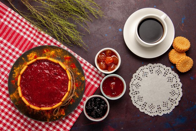 Top view cup of coffee with delicious dessert cake cookies and fruit jams on dark surface sweet fruits cookie biscuit sweet