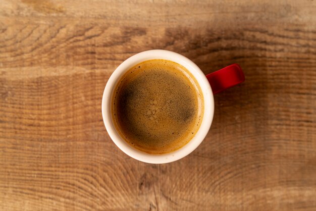 Top view cup of coffee with wooden background