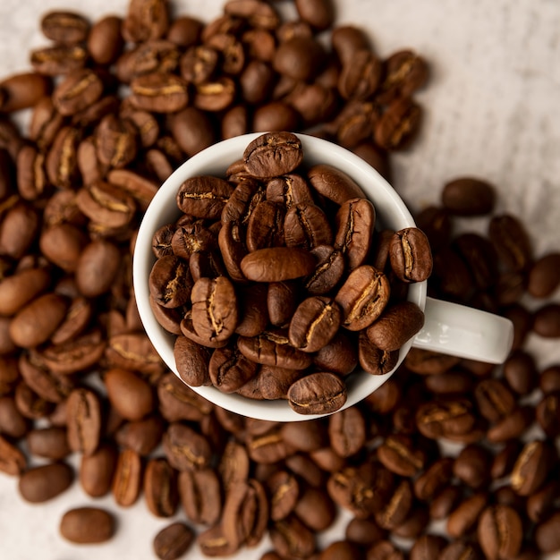 Top view cup full of roasted coffee beans