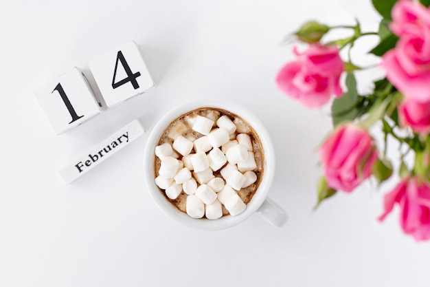 Free Photo top view of cup of marshmallows with roses and date