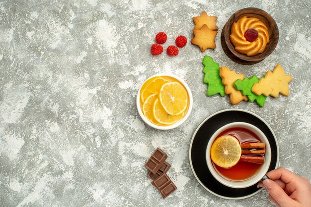 Top view cup of tea biscuit in bowl xmas tree cookies on grey surface free space