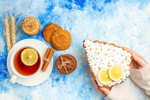 Free photo top view cup of tea cookies on blue table free space