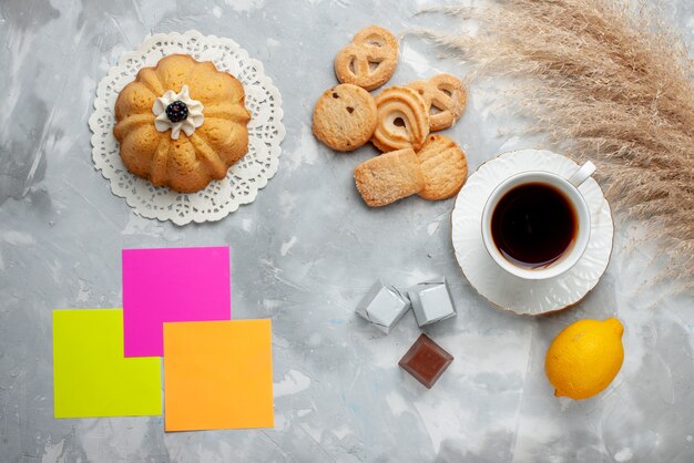 Top view of cup of tea hot with chocolate lemon little cake and cookies on light, cookie candy chocolate tea cookie sweet