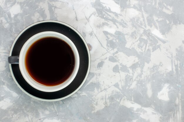 Top view cup of tea inside cup and plate on the light-white surface