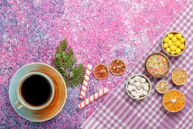 Top view cup of tea with candies on pink desk candy tea drink sweet sugar confiture color