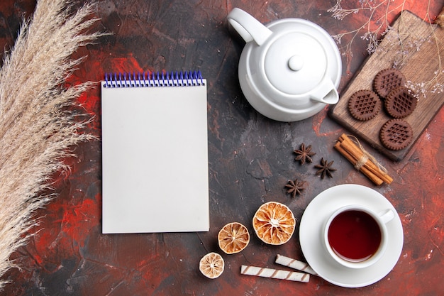 Free photo top view cup of tea with choco cookies on dark floor photo tea biscuit