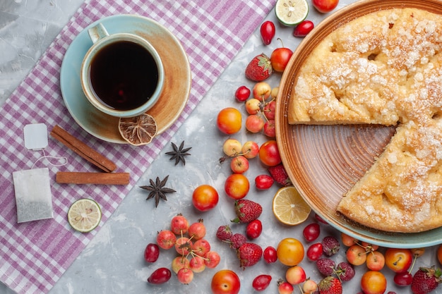 Top view cup of tea with cinnamon and fruits pie on the light desk tea drink hot breakfast