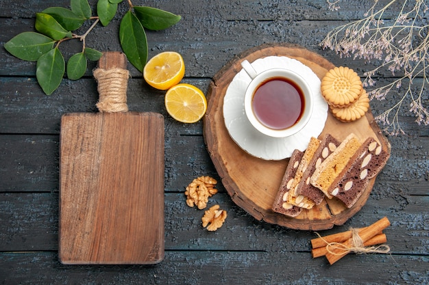 Free photo top view cup of tea with cookies and cakes on dark table sweet biscuit pie sugar