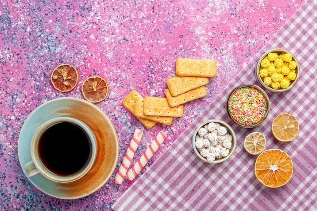 Free photo top view cup of tea with crackers and candies on the pink desk