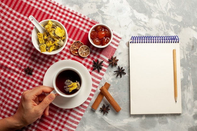 Top view cup of tea with dessert and different jams on the white desk fruit jam tea sweet sugar