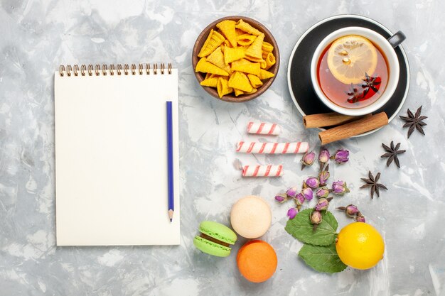 Top view cup of tea with french macarons on light-white desk