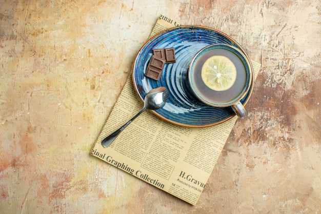 Free photo top view cup of tea with lemon on brown background