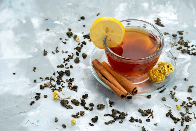 Free photo a top view cup of tea with lemon and cinnamon on bright, tea liquid fruit