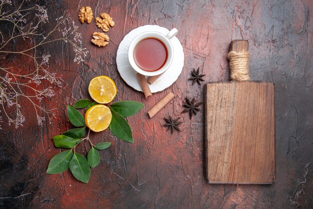 Top view cup of tea with lemon on dark table tea dark fruit