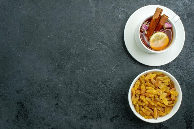 Top view cup of tea with lemon and raisins on dark surface raisin tea fruit ceremony drink