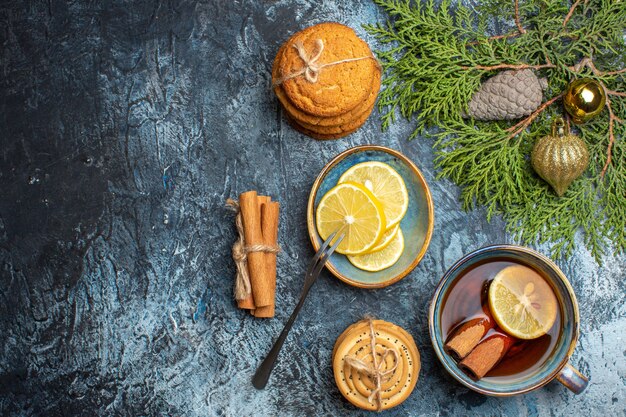 Top view cup of tea with lemon slices and biscuits on light background