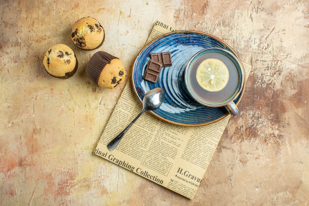 Top view cup of tea with little sweet cakes on light background