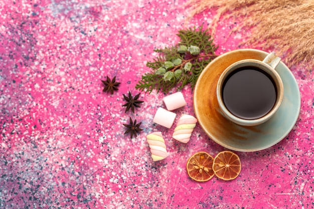 Top view cup of tea with marshmallows on the light-pink desk.