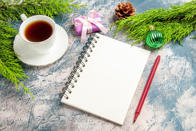 Top view cup of tea with notepad and green branch