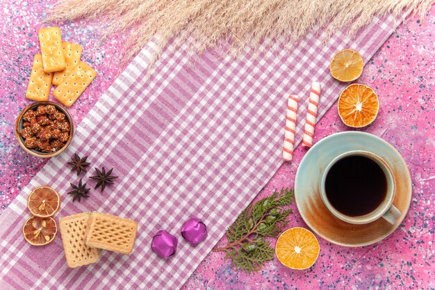 Top view cup of tea with waffles and crackers on pink