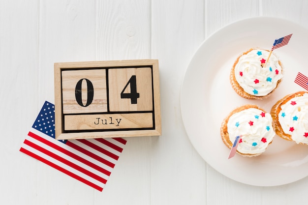 Free photo top view of cupcakes on plate with american flags and date