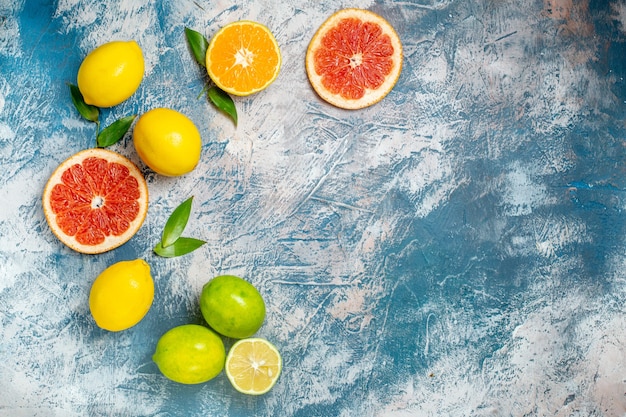 Top view cut grapefruits lemons on blue white surface free place