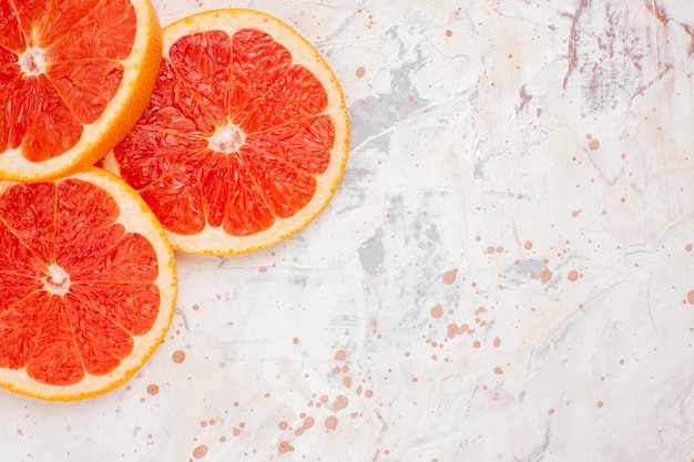 Free photo top view cut grapefruits on nude surface free space