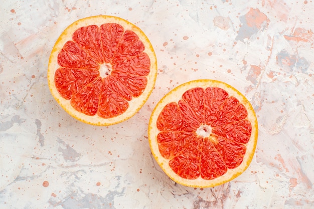 Free photo top view cut grapefruits on nude surface