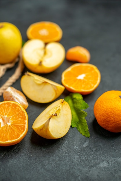 Top view cut oranges and apples cut orange on dark background